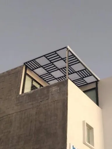 Detalle de techo o pérgola con diseño cuadriculado en metal y lámina translúcida, uno de los tipos de herrería decorativa.